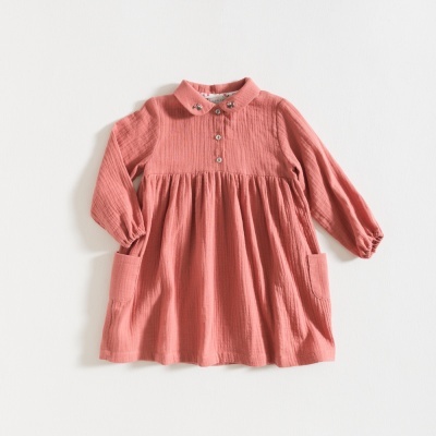 Vestido infantil rosa com gola e botões, tecido texturizado e bolsos grandes