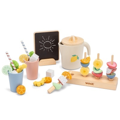 Brinquedo de cozinha em madeira com jarra, copos, frutas coloridas e quadro negro com sol desenhado