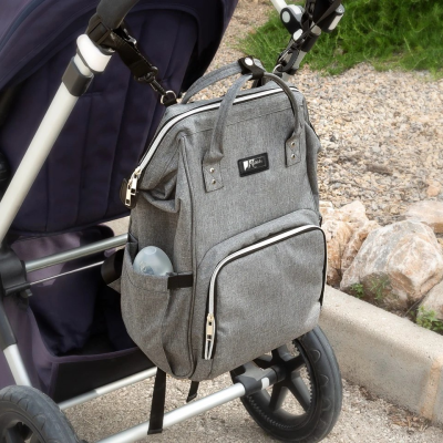 Mochila cinzenta presa a carrinho de bebé azul escuro com garrafa de plástico na lateral