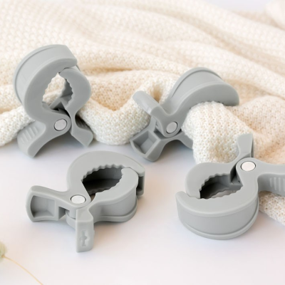 Quatro grampos de silicone cinza claro sobre tecido de malha bege