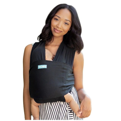 Mochila porta-bebé preta MOBY usada por mulher com vestido riscas pretas e brancas