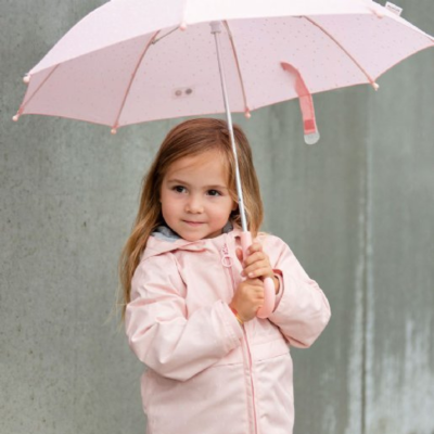 Menina de casaco rosa segurando guarda-chuva rosa com padrão de pontos