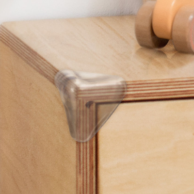 Protetor de canto transparente em móvel de madeira clara
