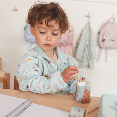 Menino em avental azul claro a pegar lápis de cor num estojo cilíndrico