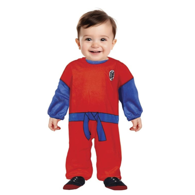 Bebé com macacão vermelho e azul e sapatos pretos num fundo branco