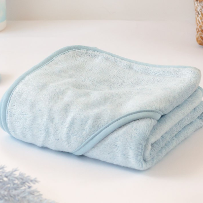 Toalha azul claro dobrada sobre superfície branca