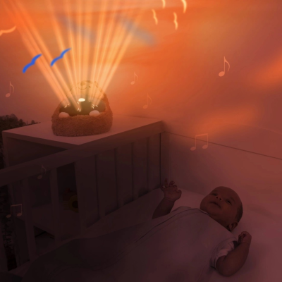 Luz projetada com notas musicais e pássaros azuis numa parede laranja próxima de berço com bebé