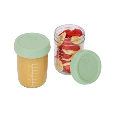 Dois frascos de vidro com tampas verdes, um com purê laranja e outro com morango e banana fatiados