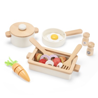 Utensílios de cozinha em madeira com legumes e ovo de brinquedo.