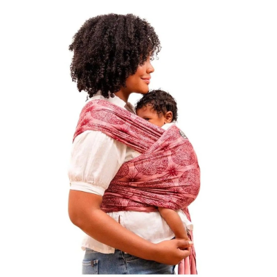 Mulher usa sling vermelho com padrões florais para segurar bebê