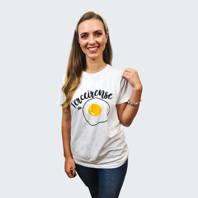 Mulher a usar camisola branca com estampa de ovo e texto 'Torceirense'