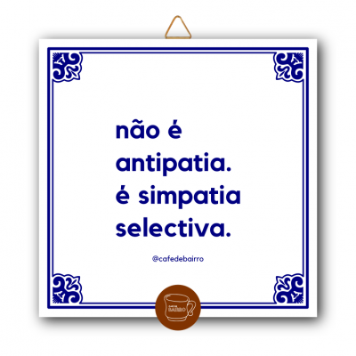 Placa decorativa branca quadrada com texto em azul e borda azul, pendurada por fio.