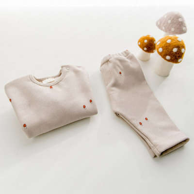 Conjunto de roupa de criança bege com estampados de cogumelos