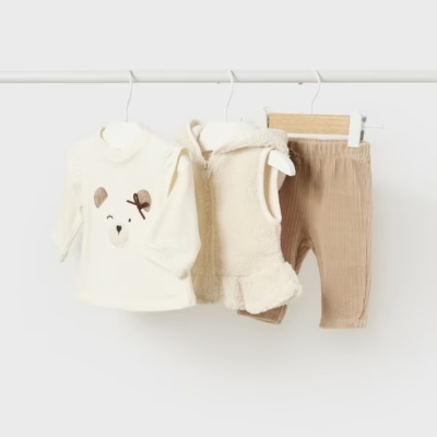 Conjunto de roupa para bebé com camisola creme, colete peludo creme e calças bege pendurados