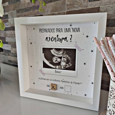 Moldura branca com ecografia e texto sobre convite para padrinhos, em ambiente com parede de azulejos rústicos.