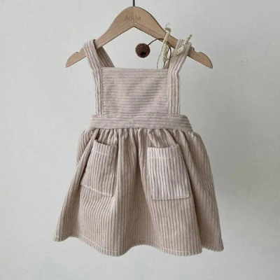 Vestido de criança bege de veludo cotelê com bolsos, pendurado