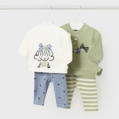 Conjuntos de roupa de bebé em branco e verde pendurados em cabides