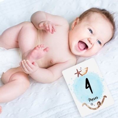 Bebé deitado com cartão de 4 meses ao lado