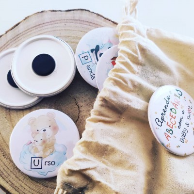 Bottons redondos com ursinhos e texto, sobre madeira e saco de pano