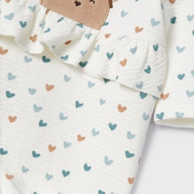 Roupa branca com corações azuis e castanhos e folho no decote