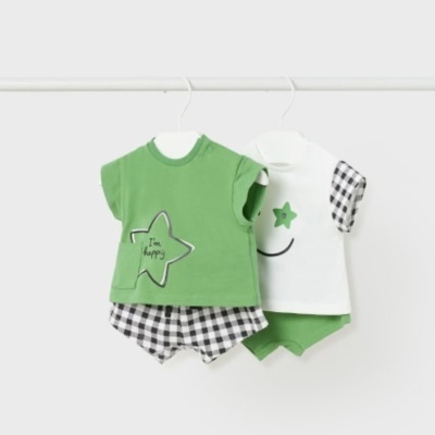 Dois conjuntos de roupa para bebé, um verde com calções xadrez e um branco com calções verdes, pendurados num cabide branco