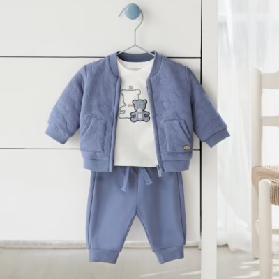 Conjunto de roupa de bebé azul e branca com casaco, t-shirt e calças pendurado