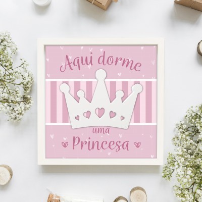 Quadro decorativo com coroa branca e texto Aqui dorme uma Princesa em fundo rosa