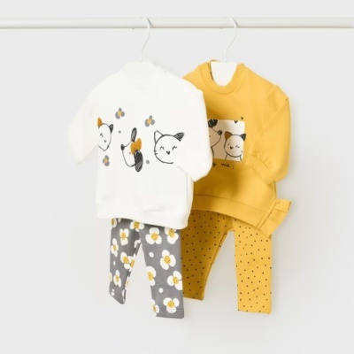 Conjuntos de roupa de infância pendurados em cabides