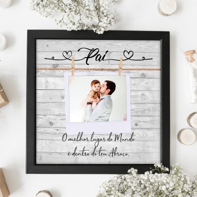 Moldura preta com moldura de madeira clara e foto de pai com filho pendurada