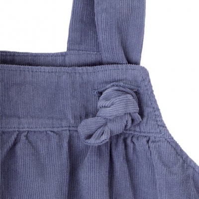 Peça de roupa infantil em veludo cotelê azul com nó decorativo