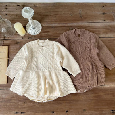 Dois vestidos de malha para bebé em creme e castanho com padrões de trança