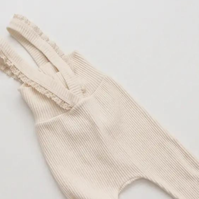 Macacão de bebé bege com alças de renda