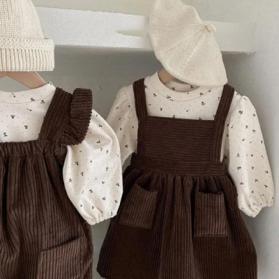 Conjunto de roupa infantil castanho e creme com vestido de veludo cotelê e camisola com padrão de estrelas