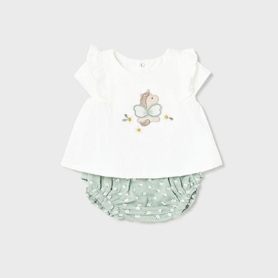 Conjunto de roupa de bebé com t-shirt branca e cuecas verdes com flores.