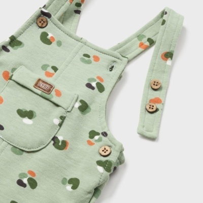 Jardineira infantil verde com padrão colorido e botões de madeira