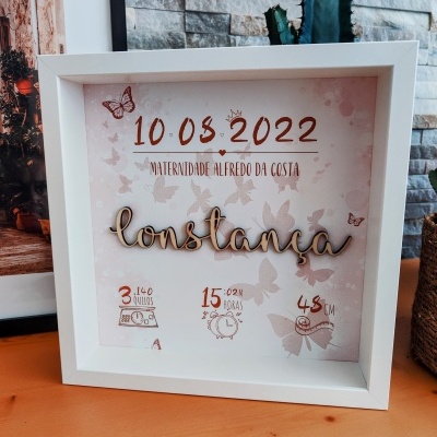 Quadro decorativo personalizado com nome Constança, data 10.05.2022, local, peso, hora e comprimento, com desenhos de borboletas em fundo rosa.