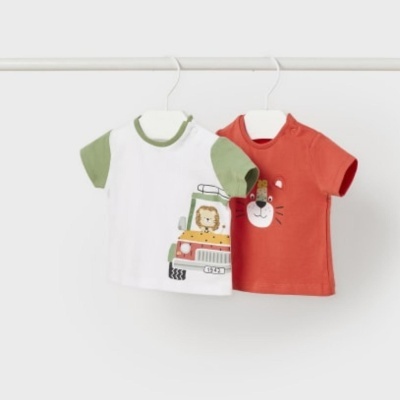 Duas t-shirts infantis, uma branca com detalhes verdes e uma vermelha, penduradas em cabides.