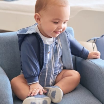 Bebé sentado numa poltrona azul com roupa azul