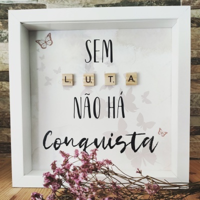 Quadro branco com mensagem com letras de madeira e flores secas em pano de fundo com borboletas