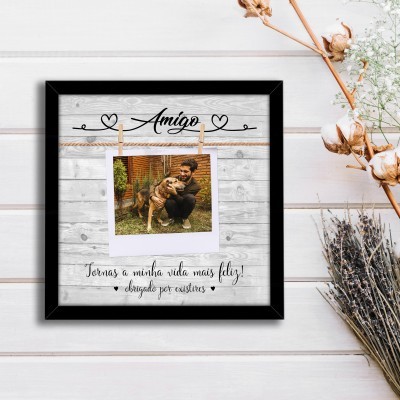 Moldura preta quadrada com foto de homem e cão e texto sentimental sobre fundo de madeira clara