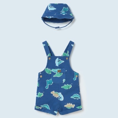Conjunto infantil azul com jardineira curta e chapéu estampado de dinossauros.