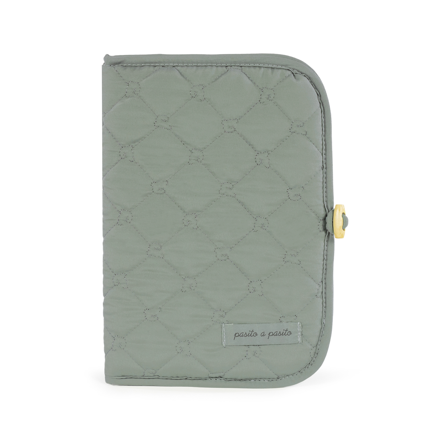 Capa acolchoada verde com padrão em losangos e etiqueta pasito a pasito.