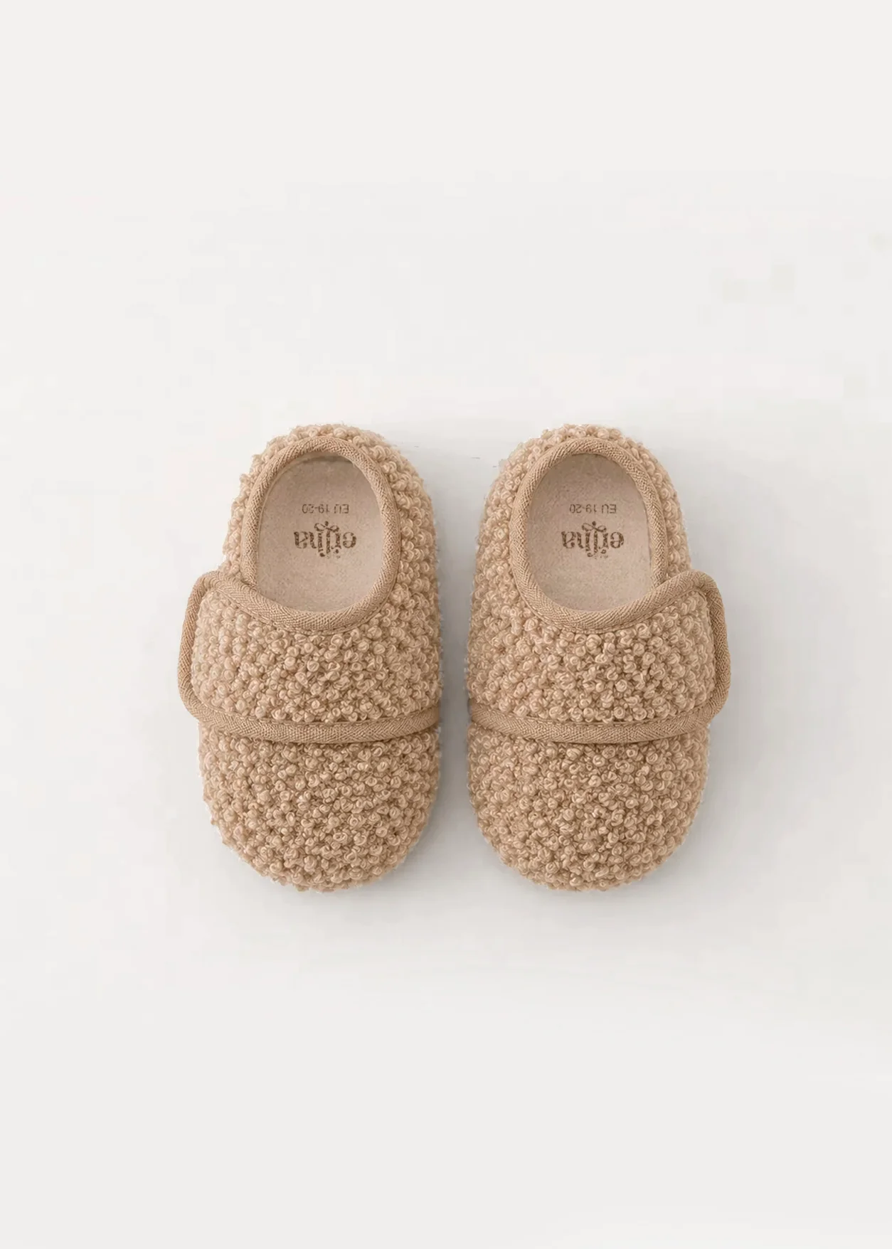 Chinelos fechados bege com textura tricot e faixa de velcro ajustável