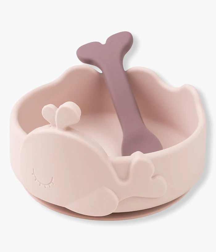 Taça de silicone rosa com design de baleia e colher roxa.