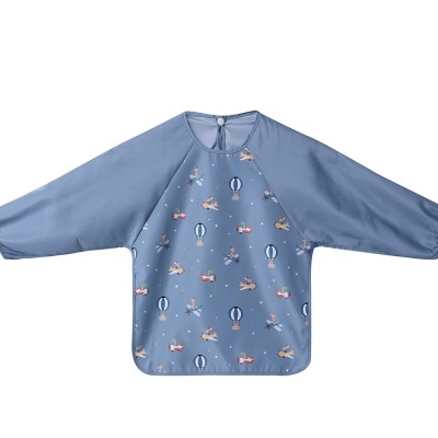 Babete infantil azul com estampado de balões e aviões e mangas compridas.