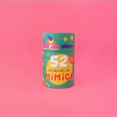 Embalagem cilíndrica verde com texto 52 Desafios de Mímica em fundo rosa