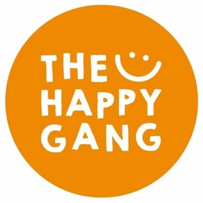 Logótipo circular laranja com texto branco 'THE HAPPY GANG' e sorriso estilizado