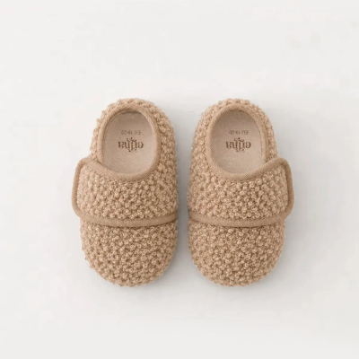 Chinelos fechados bege com textura tricot e faixa de velcro ajustável