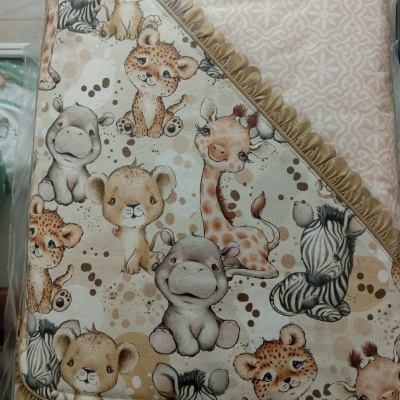 Manta para bebé com padrões de animais selvagens e bordas castanhas.