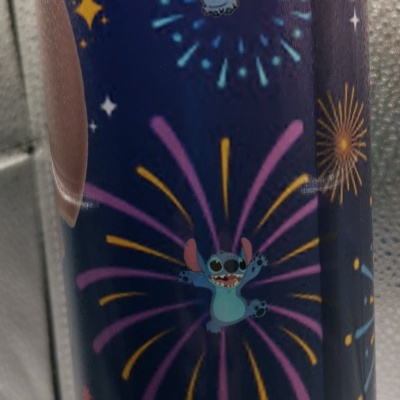 Copo azul escuro com personagens Stitch e fogos de artifício coloridos